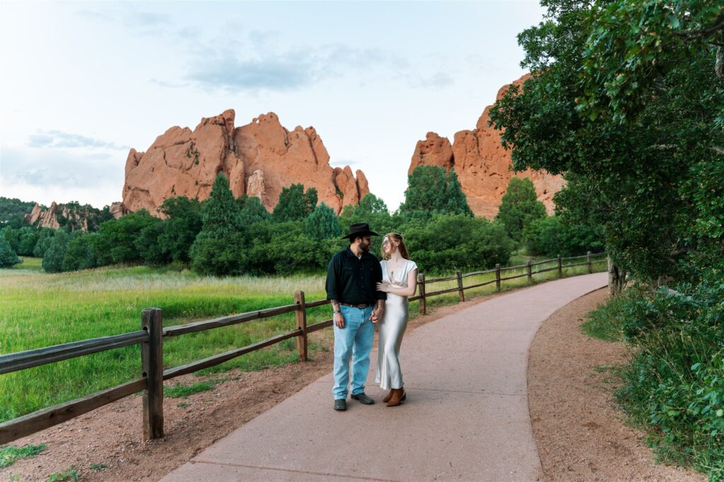 A couple walking on a path at Garden of the Gods, wearing their elopement attire.